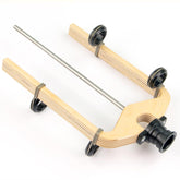 The image shows the Louët Standard Flyer with Sliding Guides, a product by Louët Inc. It features a wooden base with metal rods and four black rubberized wheels. The mount includes a black camera holder designed for stability and smooth movement, making it ideal for photography or videography purposes.