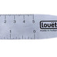 The Louët Reed Hook by Louët Inc., made in Holland, is a traditional metallic thread cutter and gauge. This smooth tool features a small ruler with measurements in centimeters, a circular hole at one end, and a hooked edge for cutting threads on the opposite end.