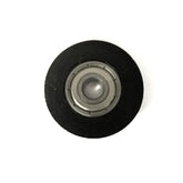 A close-up image of the Louët Roller with a ball bearing standard, encapsulated in a circular, black outer casing on a white background. The inner metallic ball is centered within the bearing, making it an ideal replacement for the Louet roll.