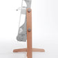 A side view of the Ashford Rigid Heddle Table Stand, a modern upright spinning wheel designed by Ashford Handicrafts Limited, showcases its wooden stand with a comfortable footrest. The frame, an elegant combination of metal and wood, features various gears and handles with a white fiber thread wound around parts of it. Set against a plain white background, the spinning wheel is highlighted beautifully.