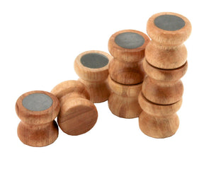 A group of small, wooden, cylindrical objects are arranged in a line. Several Lacis Kumihimo Tamas (Bobbins) made from hardwood are stacked on top of each other at varying heights. The tops of these bobbins are flat and feature circular, gray, metallic centers.