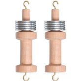 Two identical Ashford Warp Thread Weights from Ashford Handicrafts Limited, resembling classic weaving tools, positioned upright side by side on a white background. The light-colored polished wood contrasts beautifully with the shiny metal rings and hooks on both ends.