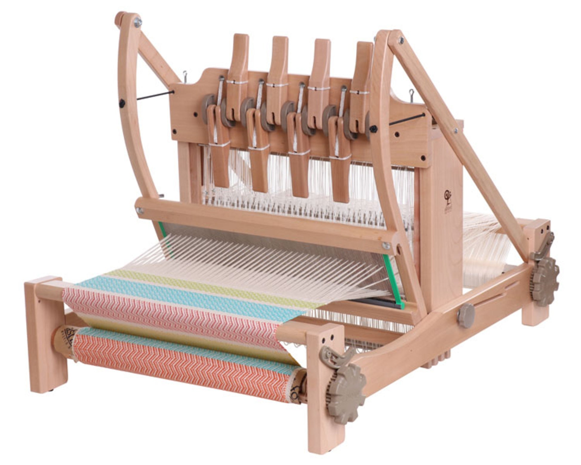 An Ashford Table Loom with an Overhead/Swinging Beater from Ashford Handicrafts Limited intricately weaves colorful horizontal striped fabric, featuring blue, green, yellow, and orange hues. Various mechanical components such as gears and Texsolv heddles are visible to manage the weaving process.