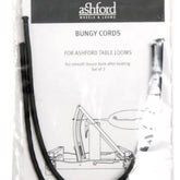 A packaged pair of Ashford Table Loom Bungy Cords from Ashford Handicrafts Limited, perfect as replacement cords. The packaging features "Ashford Wheels & Looms" at the top and "Bungy Cords for Ashford Table Looms" along with an illustration of a table loom beneath it. The black cords are coiled inside the plastic packaging, ready for use.