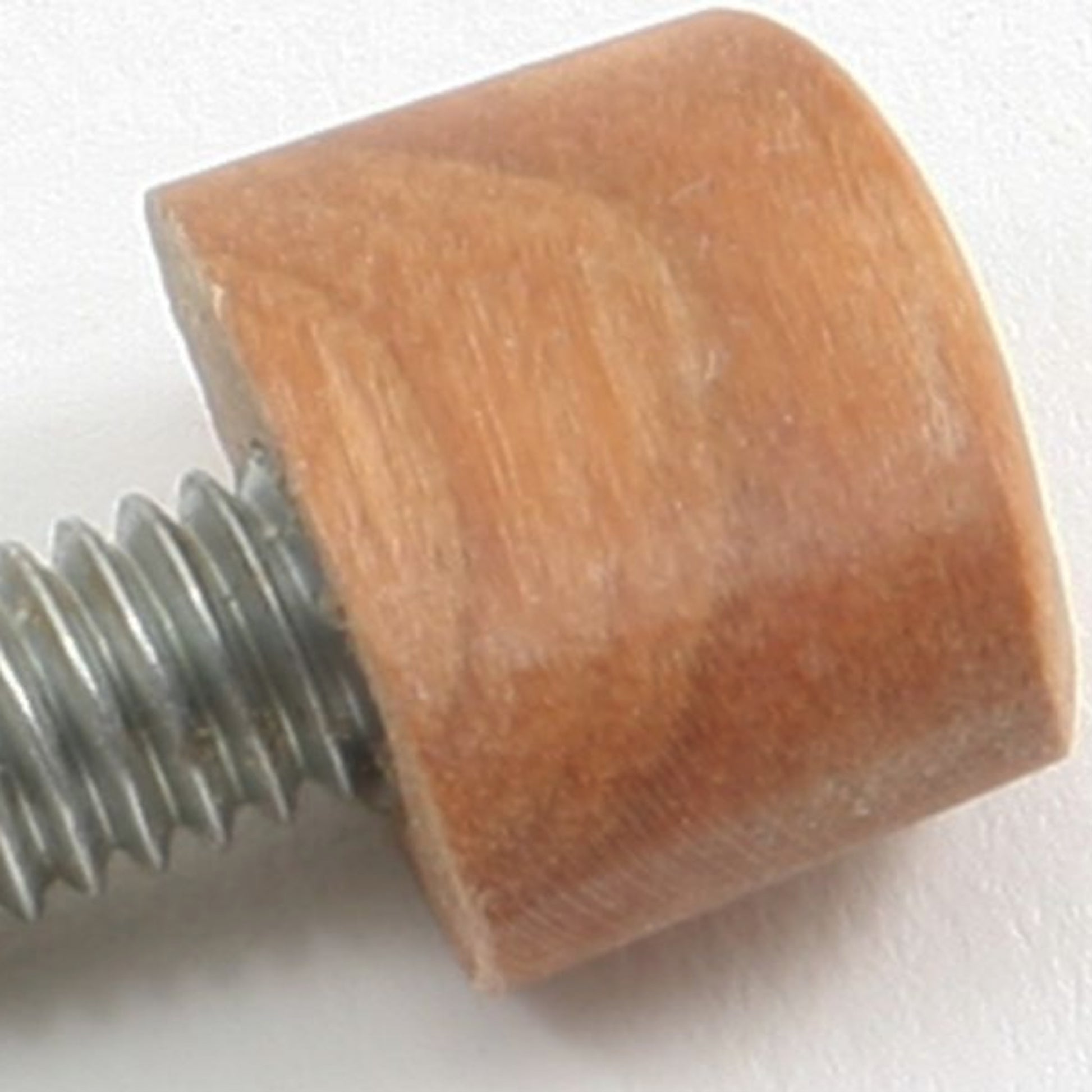 Close-up of a Replacement Knob for Cherry Swift by Thomas Siske, featuring a metal screw partially threaded into a smooth and polished wooden cylindrical piece. The wooden knob, which showcases the meticulous craftsmanship reminiscent of handmade cherry swift designs, contrasts with the sharply defined threads of the screw. The background is a plain off-white surface.