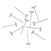 A collection of Accessories Unlimited T-pins, made of nickel-plated material, scattered on a white background. These shiny pins feature flat, T-shaped heads and pointed ends, perfect for securing items to a bulletin board and elegantly arranged in various directions.