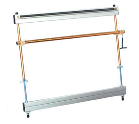 A picture showing a Mirrix Tapestry Loom by Mirrix Tapestry Looms with a sturdy metal frame structure, featuring two vertical copper pipes supported by horizontal silver bars. A wooden slider with a handle is attached to one of the copper pipes. The structure appears adjustable with screws on both sides, making it ideal for weaving projects.