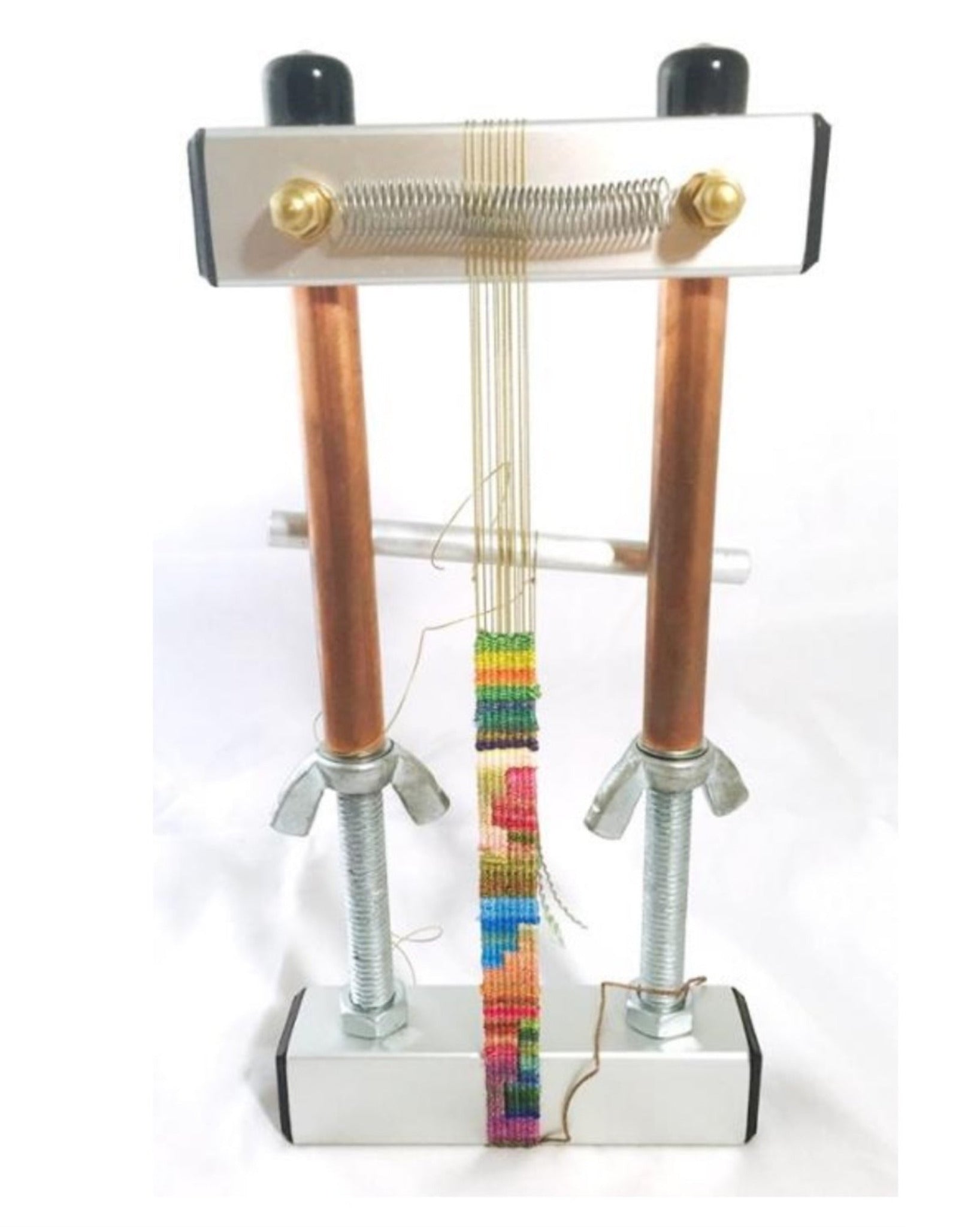 The 5" Mini Mirrix Bead Loom: "Loreli" from Mirrix Tapestry Looms features a rectangular metal frame with two vertical copper rods and large bolts at its base. This loom showcases a rainbow-colored beaded strip in progress, stretched between the rods with thin threads and a coiled spring at the top, making it perfect for experimenting with various warping methods.