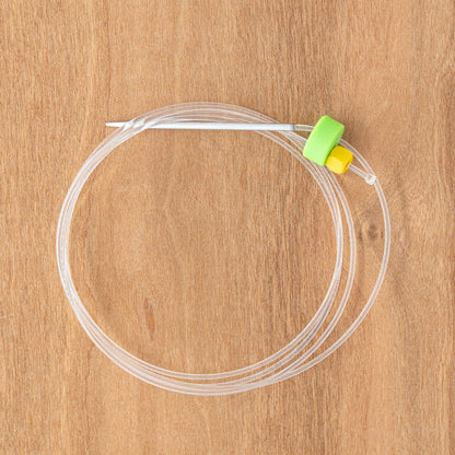 Clover Circular Needle & Stitch Holder by Accessories Unlimited, featuring a yellow clip on a green slider with an adjustable cord length, coiled neatly on a wooden surface.