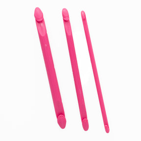 A set of three Fix-A-Stitch Tools from Accessories Unlimited, designed in pink plastic, are laid out side by side against a white background. Each tool features rounded ends and a flat middle section, making them perfect for fixing dropped stitches while knitting.