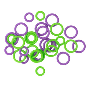 An assortment of Bryson Distributing, Inc.'s Soft Stitch Ring Markers in green and purple is gently scattered on a white background.