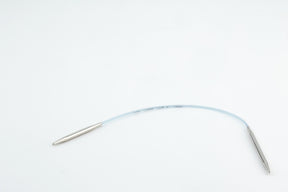 On a white background, the Addi EasyKnit Turbo Circular Needles by Skacel are displayed, featuring a flexible, clear tube connecting two cylindrical metal ends. The sleek tube, reminiscent of a medical device in design, has markings and measurements inscribed on it.