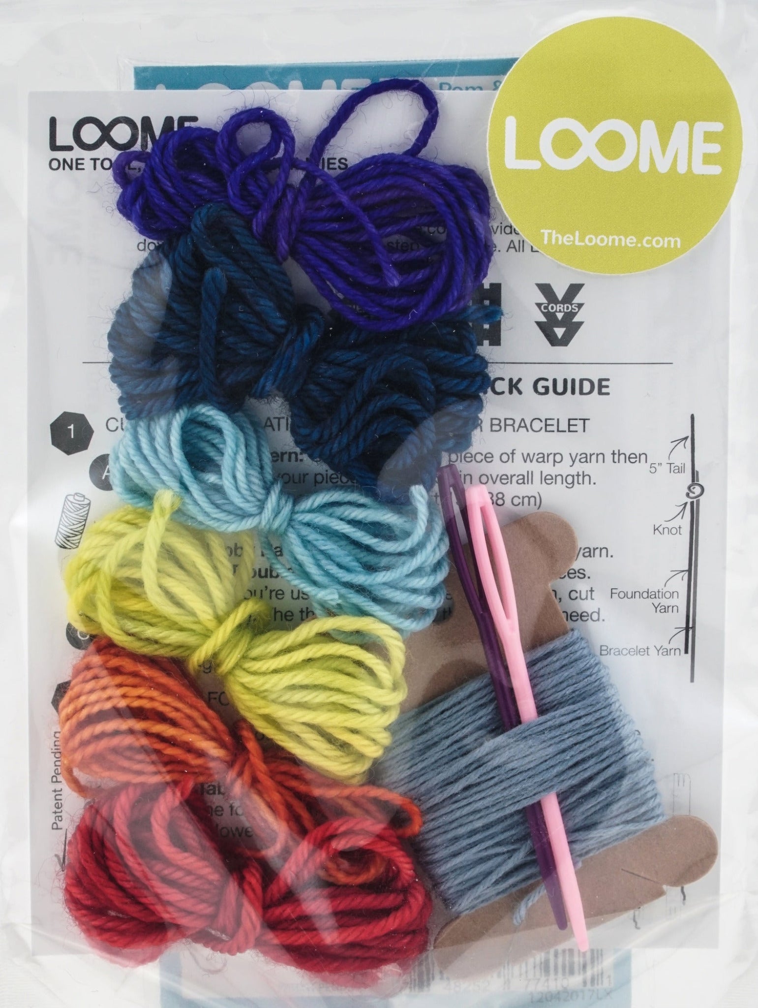 The Loome Kit - Friendship Bracelets from Loome includes an assortment of colorful yarns (purple, blue, light blue, yellow, orange, and red) arranged in loops. The kit also features a pink crochet hook, a brown cardboard spool with blue yarn, and a partially visible instruction sheet. It's perfect for creating vibrant friendship bracelets.