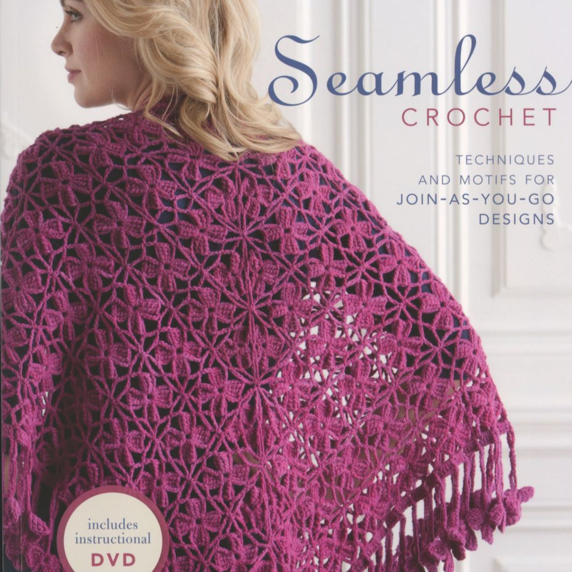 A woman is shown from the side wearing a purple crocheted shawl with a floral pattern and fringes. The image is featured on the cover of "Seamless Crochet" by Ingram Content, which highlights its helpful DVD, innovative techniques, join-as-you-go motif designs, and modular construction for advanced crochet skills.