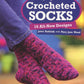 The cover of "More Crocheted Socks" by Martingale & Co showcases a close-up of a person donning cozy, purple and pink crocheted socks set against a beautifully blurred blue and yellow backdrop.