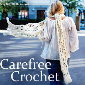 A person with long blonde hair is seen from behind, walking down a street. They wear a white crochet scarf and a white, long-sleeved top. Surrounding buildings and greenery are slightly blurred. Text on the image reads "Dynamic Openwork: Carefree Crochet" by May Britt Bjella Zamori from Ingram Content.