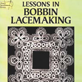 A book cover from Dover Books features an intricate lace design surrounding a square inset on a pale green background. The title, "Lessons in Bobbin Lacemaking," is displayed in bold black letters at the top, showcasing detailed patterns typical of Bobbin Lace Designs.