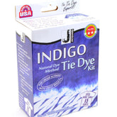 A blue and white box labeled "Indigo Tie Dye Kit" by Jacquard Products features a three-star rating symbol, the "Made in USA" logo, and text indicating it can dye more than 15 shirts. The Indigo Tie Dye Kit highlights its use of pre-reduced indigo dye, making it perfect for groups and natural fibers.