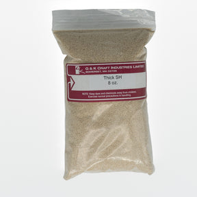 A clear plastic bag labeled "G & K Craft, Sodium Alginate Thickener, 8 oz." contains a light brown granular substance derived from seaweed. The bag has a red label with handling precautions.