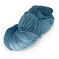 A skein of Great Adirondack Organic DK Cotton from Great Adirondack Yarn Co, Inc. is neatly coiled on a white background. The hand-dyed organic cotton yarn is variegated, showcasing shades of light to medium blue, and has a soft, slightly shiny texture.
