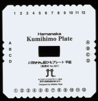 A white square BraidersHand Kumihimo Plate by Braiders Hand/Saunders, designed by Makiko Tada. Perfect for portable projects, it features numbers 1 to 12 around the edges and columns labeled A, B, C, D. There are notches around the edges and a hole in the center for creating braids. Text is in Japanese and English.