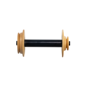 A Schacht Cherry Matchless Bobbin by Schacht Spindle Co. is standing vertically. It features two light brown wooden end disks positioned at both ends of the black, cylindrical center section. The middle section of the bobbin is a long, smooth black cylinder, and it all stands against a plain white background.