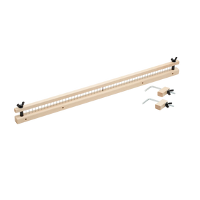 A Schacht Raddle for Standard Floor Looms by Schacht Spindle Co. is a long, narrow piece of wood with evenly spaced holes along its length, accompanied by two metal components with pins and handles, likely used for precise measurements or woodworking alignments.