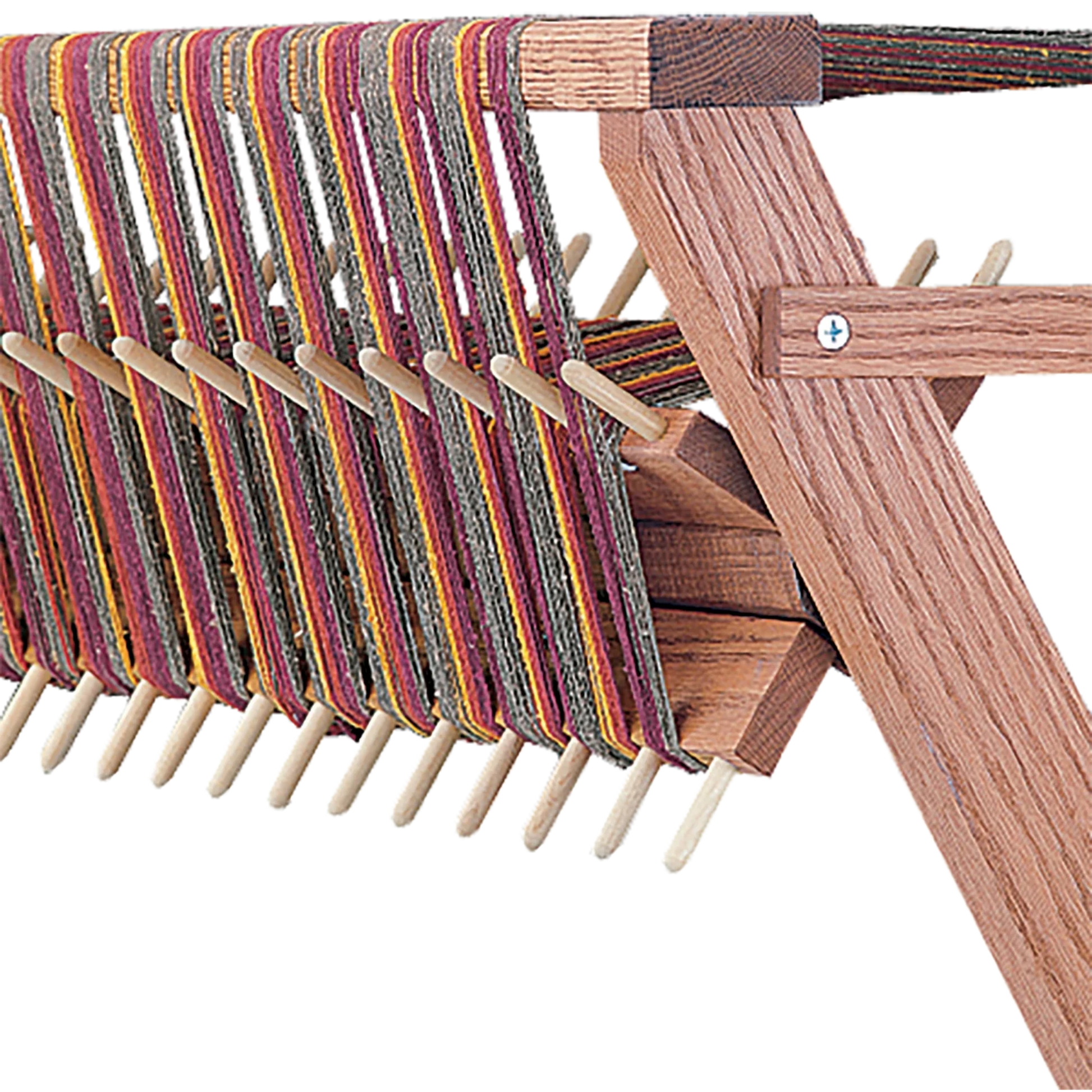 A close-up view of a wooden weaving loom with multicolored threads. The Schacht Sectional Warp Beam for Standard Floor Loom, by Schacht Spindle Co., features evenly spaced pegs, angled supports, and a sectional warp beam, showcasing a traditional crafting tool used for weaving textiles.