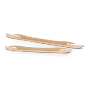 Two Schacht Ski Shuttle utensils, designed with a sleek and stylish appearance, are positioned parallel to each other on a white background. These 18" shuttles by Schacht Spindle Co. feature flat, slightly curved shapes with tapered ends, reminiscent of tools used in weaving looms and combining the functionalities of a fork and a spoon.