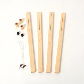 Components for a weaving loom on a white background include four wooden warp sticks, two black and two tan plastic caps, four wooden pieces, and a bundle of white string with some small attached clips. These versatile parts are ideal for your Schacht Wolf Loom by Schacht Spindle Co. and can be enhanced with the Schacht Wolf Loom 4-Treadle Add-On Kits.