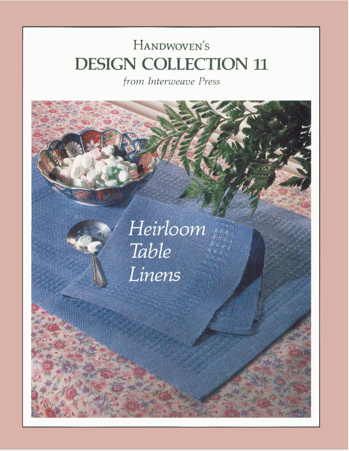 The image features the cover of the "Handwoven Design Collection #11, Heirloom Table Linens eBook" from Long Thread Media, showcasing table linens in blue fabric adorned with a bowl of sweets and a silver spoon on top. A fern frond can be seen in the background.