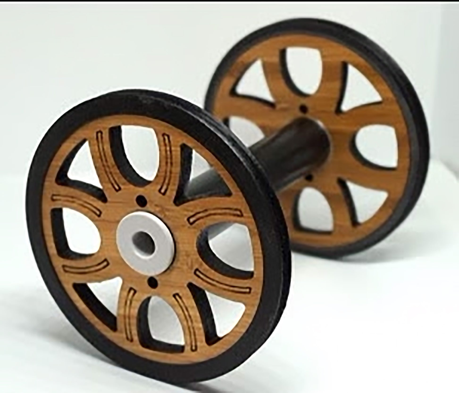 The Majacraft Co. Majacraft Wood (Bamboo) Standard Bobbin features intricately designed wheels on each end with a symmetrical pattern of cutouts, black handles and inner rims, while the main part of the wheels retains the natural bamboo color.