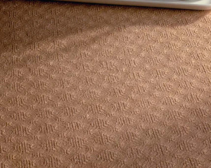 Close-up image of the texture from 'Best of Handwoven Yarn Series: A Dozen Projects in 10/2 Pearl Cotton (Printed Version)' by Long Thread Media. In the upper part of the image, a white baseboard or furniture piece casts shadows on this intricately woven, beige fabric with a subtle pattern.