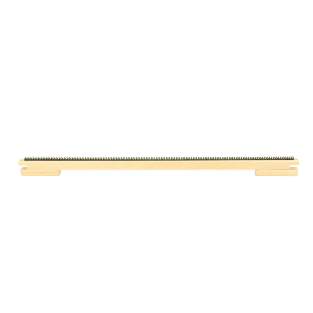 A long, thin, gold-colored metal rod from Louët Inc., designed with evenly spaced notches along its entire length and featuring rectangular extensions at both ends, appears to be a linear gear rack used in mechanical systems, likely intended as the Louët Raddle for Magic Dobby to facilitate easier warping.