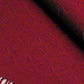 A close-up of the Best of Handwoven Yarn Series: A Dozen Projects in 10/2 Pearl Cotton (Printed Version) by Long Thread Media displays a red and purple woven tablecloth with intricate star-shaped patterns. The textile has a rich texture and includes fringe details at the edge. The vibrant colors and detailed weaving highlight the craftsmanship of this exquisite fabric.