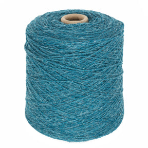 A large spool of Bartlettyarns' Bartlett Maine Wool, Sport Weight Cones in blue stands upright on a white background, with its homespun texture and tightly wound yarn visibly revealing the cardboard core.