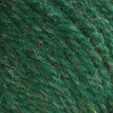 A close-up of Bartlettyarns' Bartlett Maine Wool Sport Weight Cones reveals its textured, homespun appearance; the soft, slightly fuzzy yarn features fine fibers in various shades of green for a natural, earthy look.