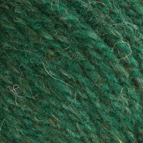 A close-up of Bartlettyarns' Bartlett Maine Wool Sport Weight Cones reveals its textured, homespun appearance; the soft, slightly fuzzy yarn features fine fibers in various shades of green for a natural, earthy look.