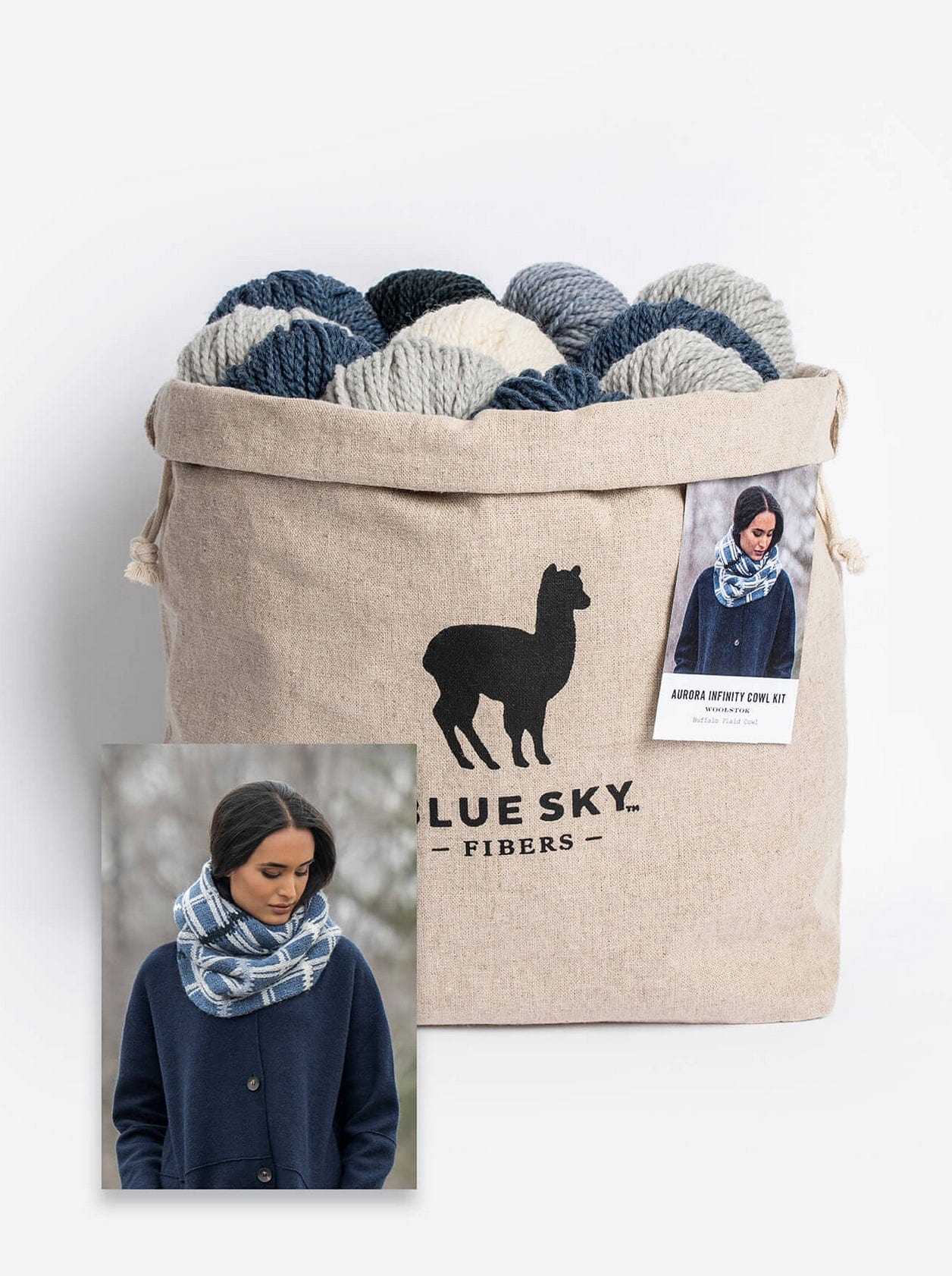 A beige drawstring bag with the "Blue Sky Fibers" logo holds blue and gray yarn balls. The inset shows a person wearing an Aurora Infinity Cowl, exuding woolly warmth. A product tag suggests knitting instructions are included in the Blue Sky Fibers Aurora Infinity Cowl Knitting Kit.