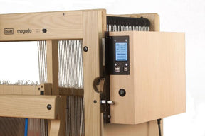 A Louët Megado Floor Loom by Louët Inc. features a wooden structure equipped with a digital display and control panel. This sophisticated dobby loom includes various moving components, such as levers and strings, specifically engineered for crafting intricate weaving patterns in textiles.