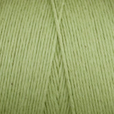 A close-up of the Cotton Carpet Warp 8/4 spool shows tightly wound, light green fibers perfect for rag rugs. The clear texture and diagonal seam create a unique pattern, while its careful crafting ensures durability and vibrant colorfastness.