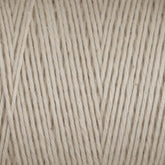 Close-up of a skein of Cotton Carpet Warp 8/4 yarn, ideal for crafting rag rugs. The tightly wound strands showcase the beige texture and thickness, forming neat parallel lines for a uniform, durable surface.