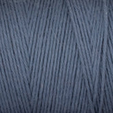 Close-up of Cotton Carpet Warp 8/4 yarn in slate blue, resembling rag rug texture. This soft, fluffy cotton warp features tightly woven fibers with a consistent diagonal pattern in a muted blue shade.