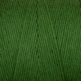 A close-up of Cotton Carpet Warp 8/4 yarn reveals tightly wound green fibers with diagonal lines, offering a soft, slightly shiny texture for a smooth finish—perfect for weaving colorfast rag rugs.