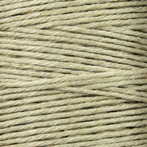 A close-up of a spool of beige twine displays tightly wound fibers, similar to Soft Finish Linen Warps used in tapestry weaving. Its coarse, natural texture and visible horizontal strands echo the craftsmanship found in Scandinavian rug creation.