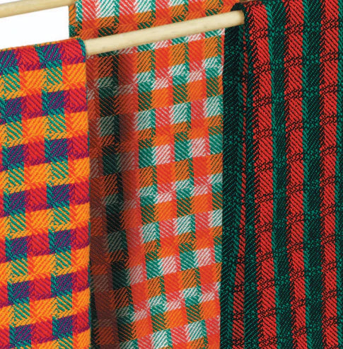 Displayed on a wooden rod are three vibrant woven textiles from the "Best of Handwoven Yarn Series: A Dozen Projects in 10/2 Pearl Cotton" by Long Thread Media. The textile on the left showcases an orange, yellow, blue, and purple checkered pattern. The middle features a design reminiscent of tablecloth towels with orange, white, green, and red checks. The right textile boasts striking green and red stripes accented with hints of black.