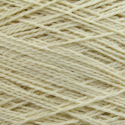 Close-up of a ball of Worsted Wool Warps by Jagger Brothers, Inc. The cream-colored fibers are loosely wound and exhibit a slightly textured appearance, highlighting various individual strands interwoven. This soft yarn, ideal for Navajo designs or other weft-face projects, is perfect for knitting or crocheting endeavors.