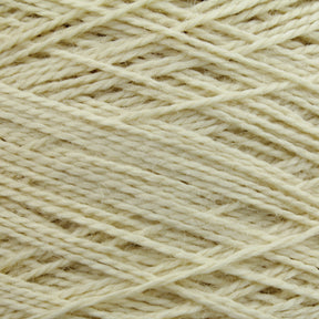 Close-up of a ball of Worsted Wool Warps by Jagger Brothers, Inc. The fibers are tightly interwoven, creating a textured, crisscross pattern reminiscent of Navajo designs. The yarn appears soft and slightly fuzzy, with a natural, wool-like consistency.