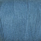 Close-up image of a spool of blue yarn. The yarn, part of the 8/2 Cottolin Organic Yarn | Tube by Maurice Brassard, is tightly wound into neat layers and has a slightly textured surface, showcasing a consistent blue color throughout.