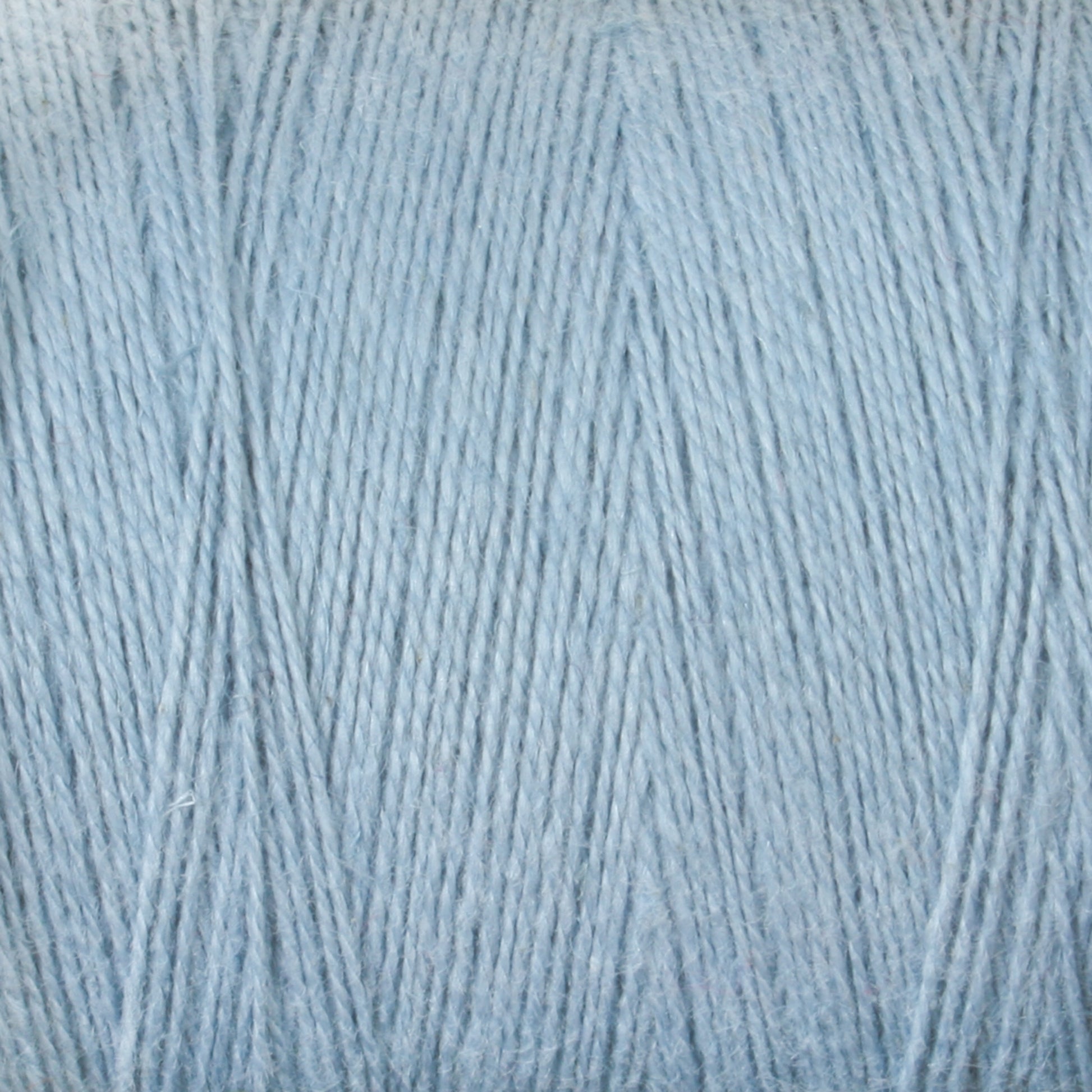 Close-up of a light blue Maurice Brassard 8/2 Cottolin Organic Yarn, showcasing fine and soft strands tightly wound together. The texture features a subtle sheen, giving it a slightly glossy appearance. Made from a cotton linen blend, the yarn's hue appears uniform throughout the image.